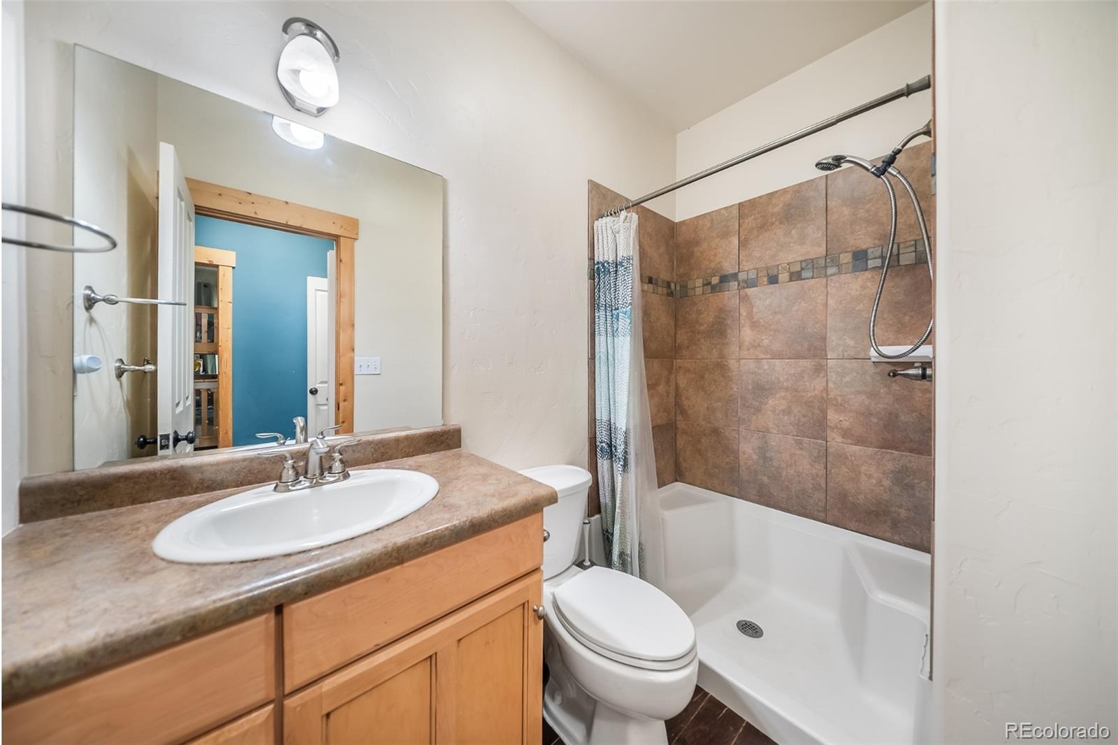 143 East Grand Avenue Hot Sulphur Springs, CO 80451 - Photo 18 of 37 a bathroom with a granite countertop sink toilet and shower