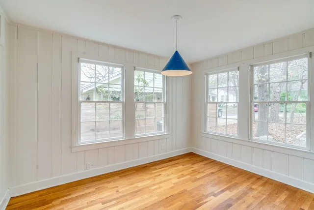 a view of an empty room with chandelier and a window