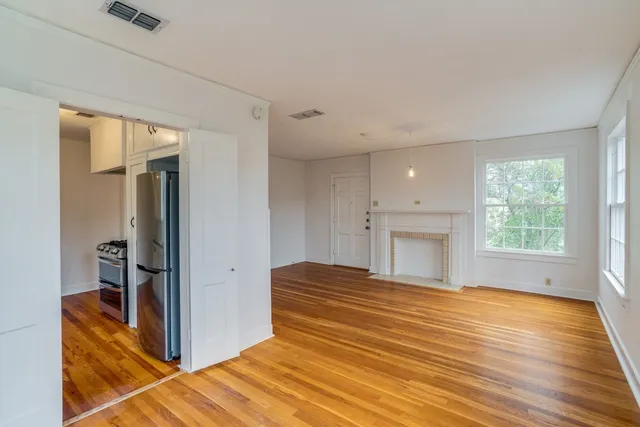 a bedroom with a bed and a dresser next to a window