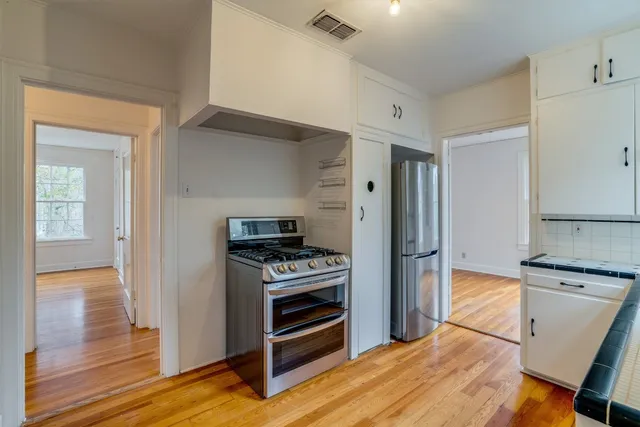 a kitchen with a refrigerator and a stove top oven