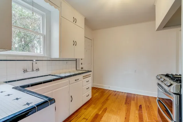 a view of a kitchen with a sink dishwasher and wooden floor