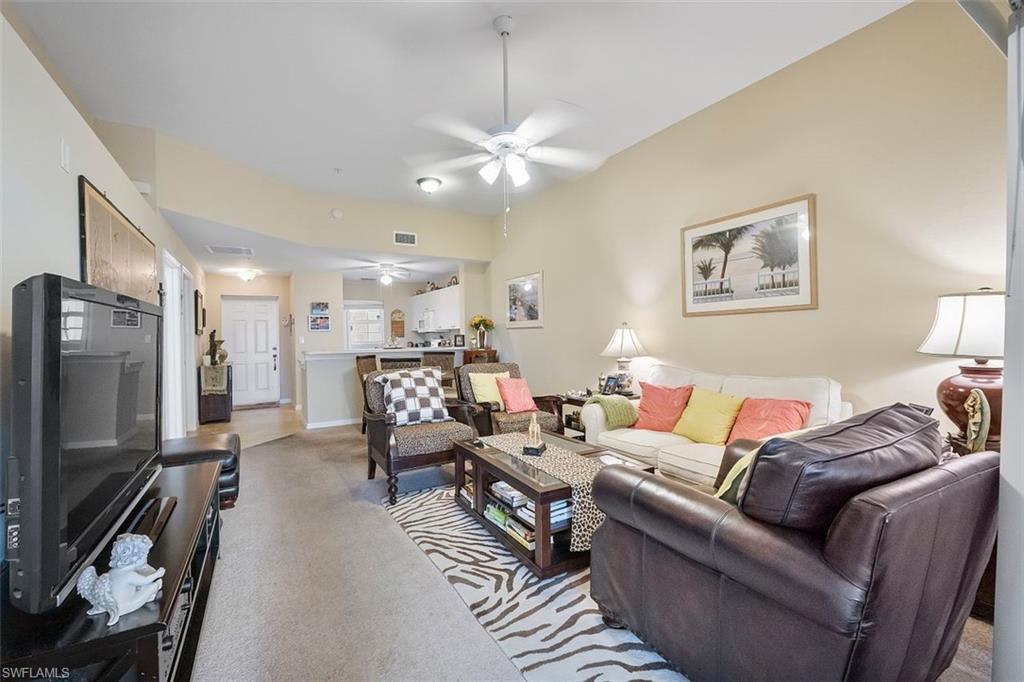 4500 Botanical Pl Circle, Unit 404 Naples, FL 34112 - Photo 14 of 31 Living room with light carpet and ceiling fan