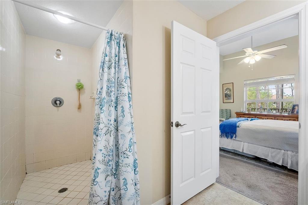 4500 Botanical Pl Circle, Unit 404 Naples, FL 34112 - Photo 21 of 31 Bathroom featuring ceiling fan and a shower with curtain