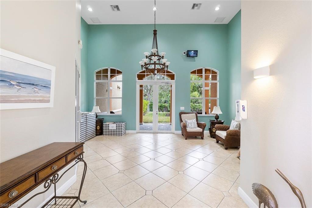 4500 Botanical Pl Circle, Unit 404 Naples, FL 34112 - Photo 23 of 31 Living area with a high ceiling, light tile patterned floors, and a chandelier