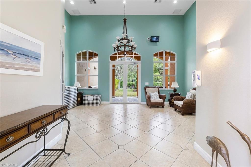 4500 Botanical Pl Circle, Unit 404 Naples, FL 34112 - Photo 25 of 31 Sitting room with a towering ceiling, an inviting chandelier, and light tile patterned floors