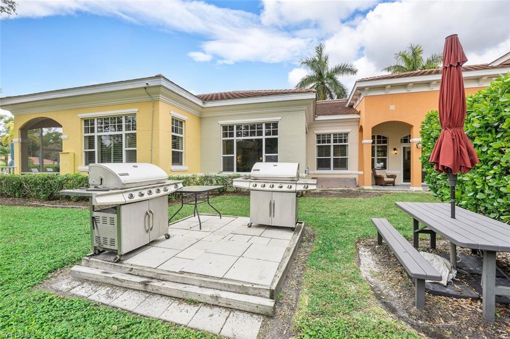 4500 Botanical Pl Circle, Unit 404 Naples, FL 34112 - Photo 31 of 31 Rear view of property featuring a patio area and a lawn
