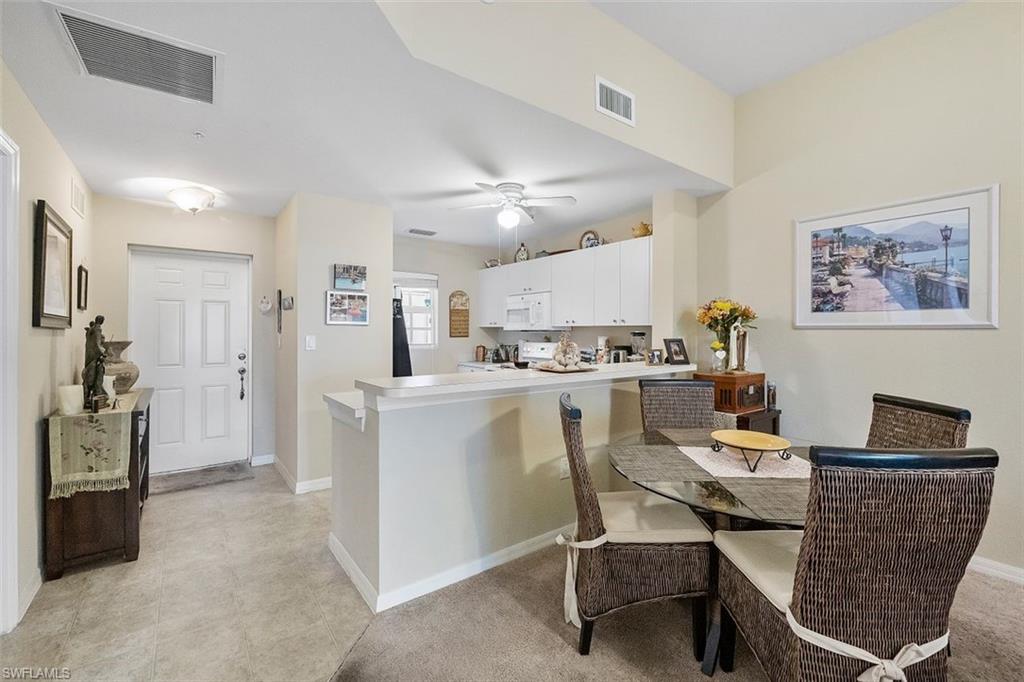 4500 Botanical Pl Circle, Unit 404 Naples, FL 34112 - Photo 4 of 31 Dining area featuring ceiling fan and light carpet
