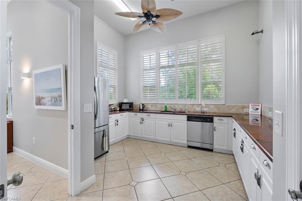 4500 Botanical Pl Circle, Unit 404 Naples, FL 34112 - Photo 5 of 31 Kitchen featuring stainless steel appliances, white cabinetry, sink, and plenty of natural light