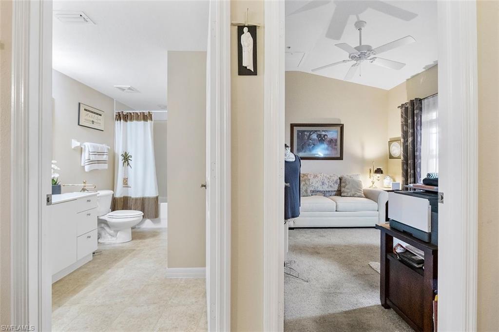 4500 Botanical Pl Circle, Unit 404 Naples, FL 34112 - Photo 7 of 31 Full bathroom with shower / tub combo, vaulted ceiling, toilet, vanity, and ceiling fan