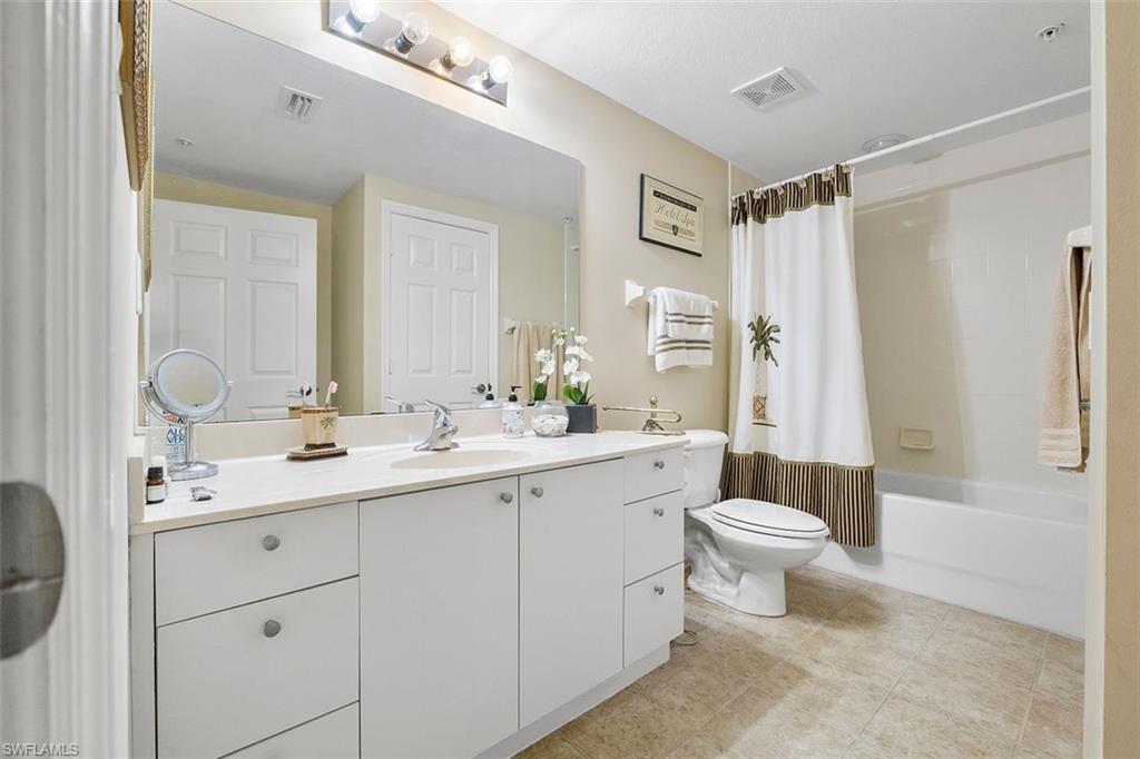 4500 Botanical Pl Circle, Unit 404 Naples, FL 34112 - Photo 9 of 31 Full bathroom featuring vanity, shower / bath combo with shower curtain, and toilet