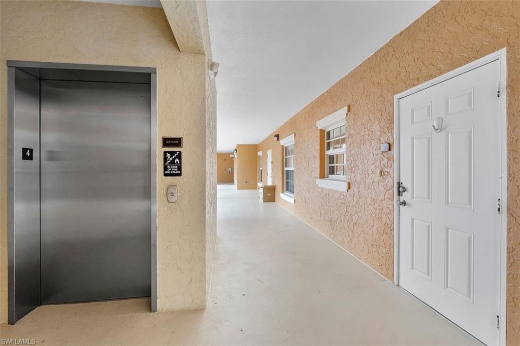 4500 Botanical Pl Circle, Unit 404 Naples, FL 34112 - Photo 10 of 31 Corridor featuring concrete flooring and elevator
