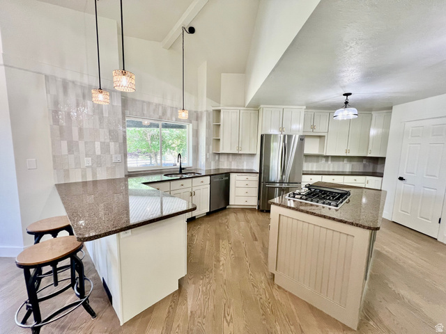 812 East Bates Cyn Road Tooele, UT 84074 - Photo 19 of 144 Kitchen featuring white shaker cabinetry, speckled countertops, a gas cooktop island, stainless steel appliances, and wood-finish flooring