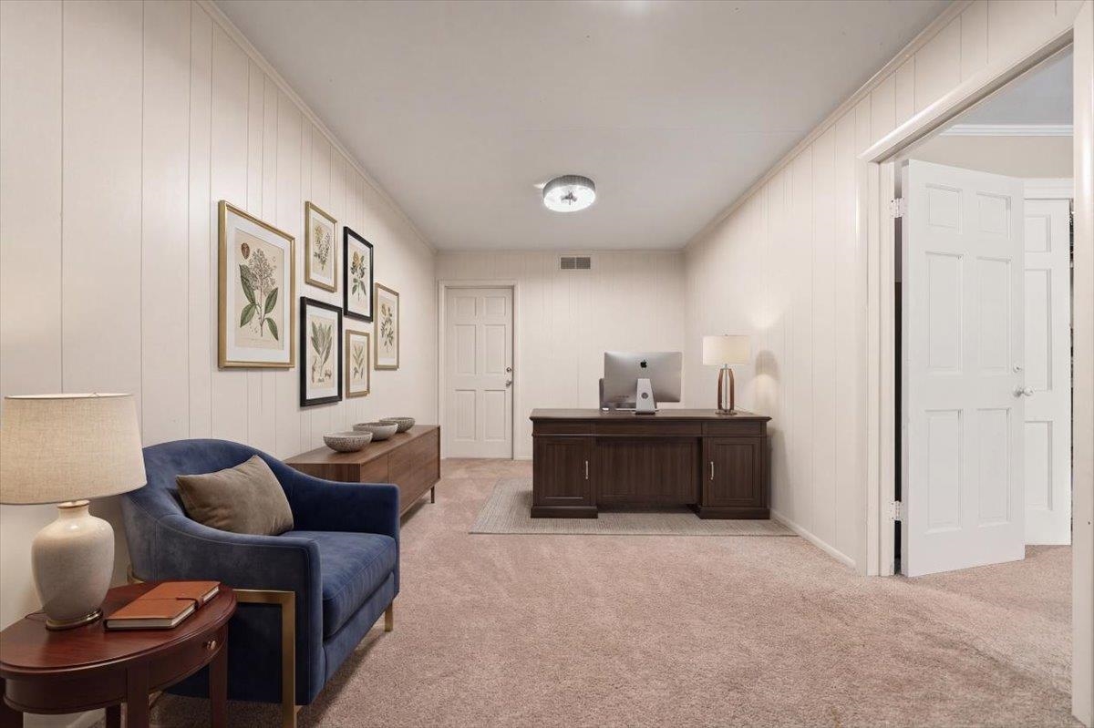 1273 Brookfield Road Memphis, TN 38119 - Photo 31 of 40 Virtually staged as an office space; featuring plush carpeting, vertical wall paneling, a ceiling-mounted light fixture, and white bi-fold doors; currently being used as storage room;