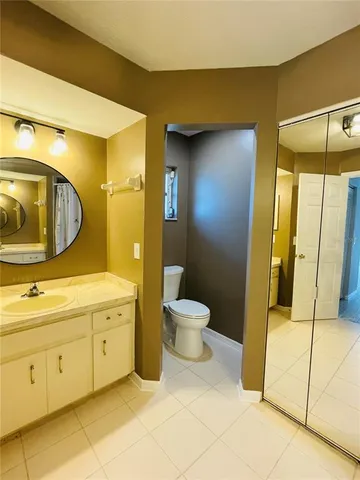 a bathroom with a double vanity sink toilet and mirror