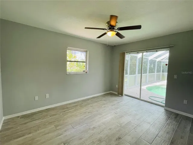 an empty room with fan and windows