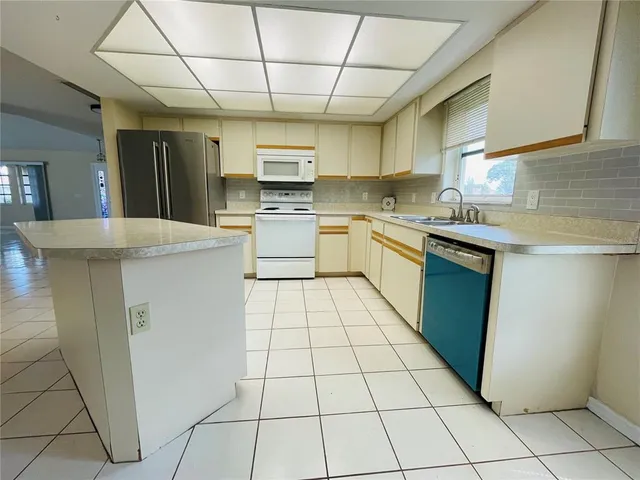 a kitchen with stainless steel appliances granite countertop a stove a sink dishwasher and a refrigerator