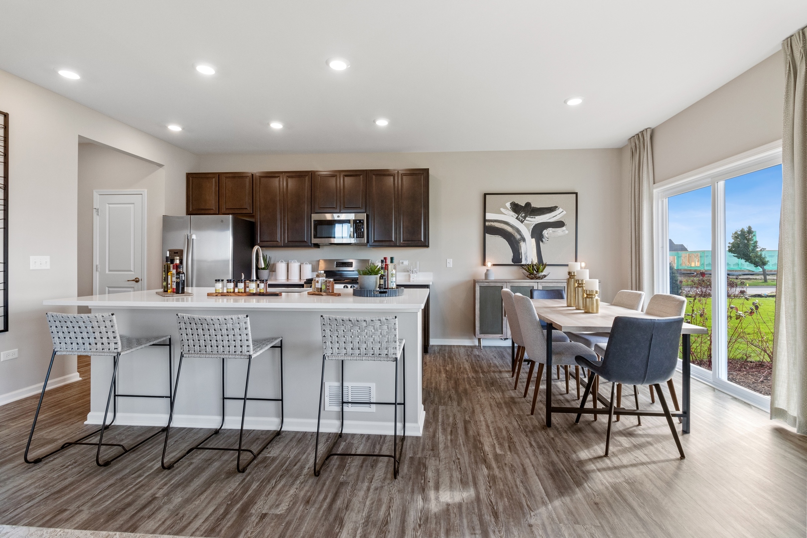 25602 Springview Drive Plainfield, IL 60586 - Photo 8 of 27 a kitchen with stainless steel appliances granite countertop a dining table chairs refrigerator and sink