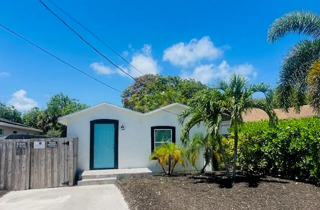 a view of a house with potted plants and wooden fence