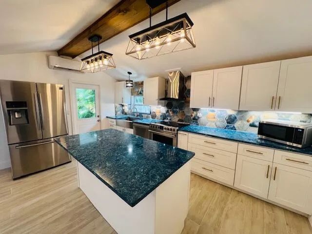 a kitchen with granite countertop a sink a counter space appliances and cabinets