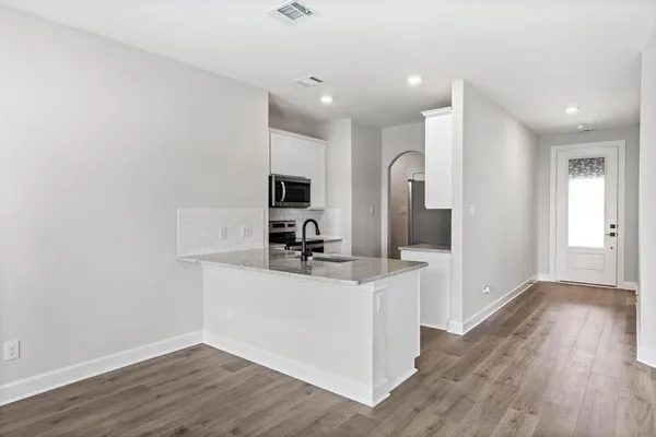 a kitchen with cabinets and wooden floor