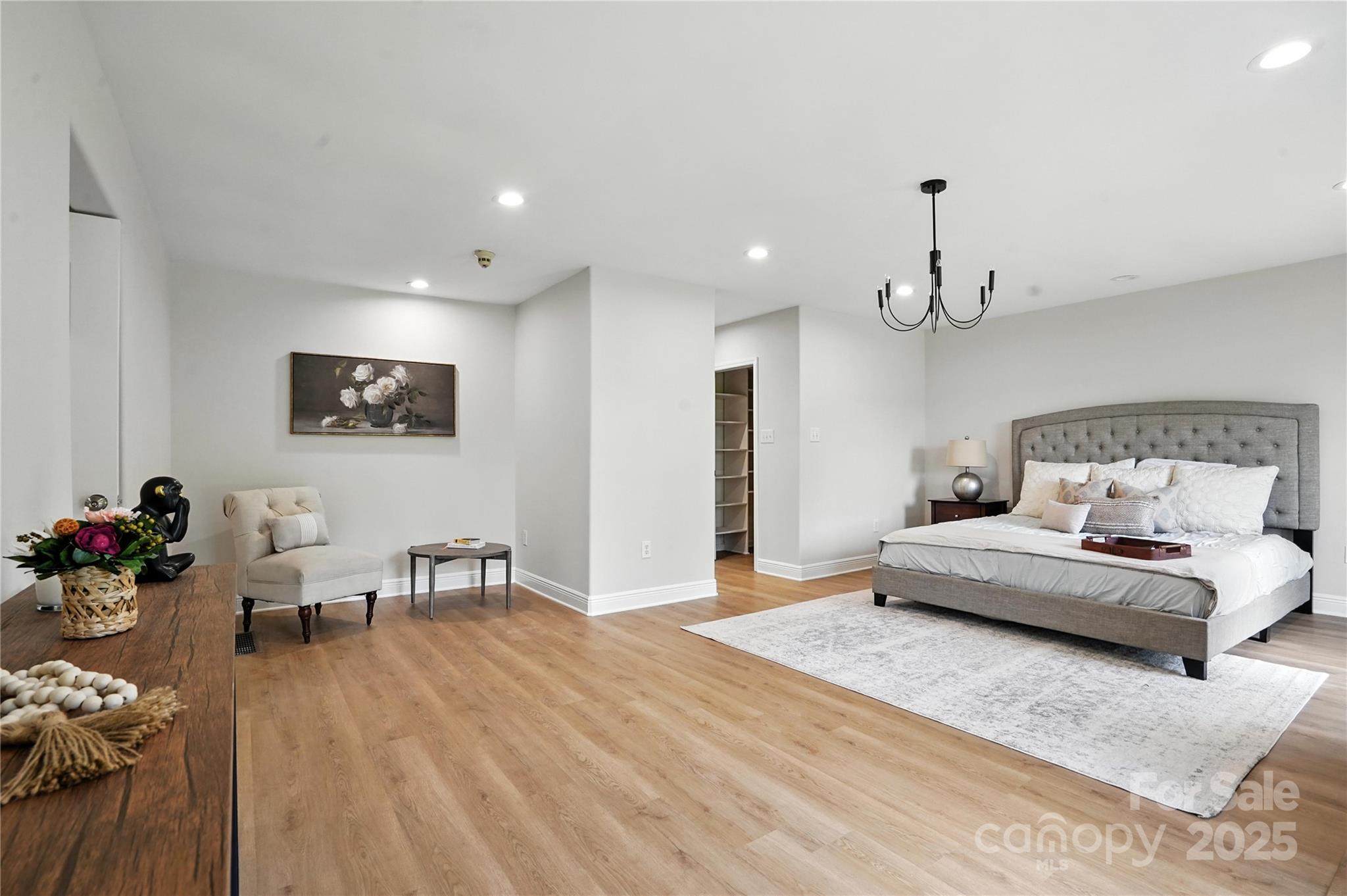 7109 Forney Hill Road Denver, NC 28037 - Photo 18 of 45 a spacious bedroom with a bed a couch and a dresser with wooden floor