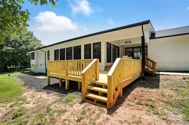 a view of a deck with wooden floor and fence with a bench