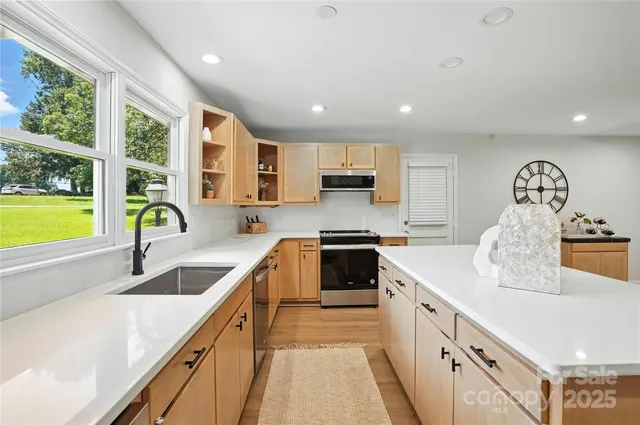 a kitchen with granite countertop a sink a counter space appliances and cabinets