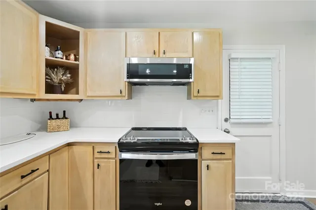 a kitchen with stainless steel appliances granite countertop a sink stove and cabinets