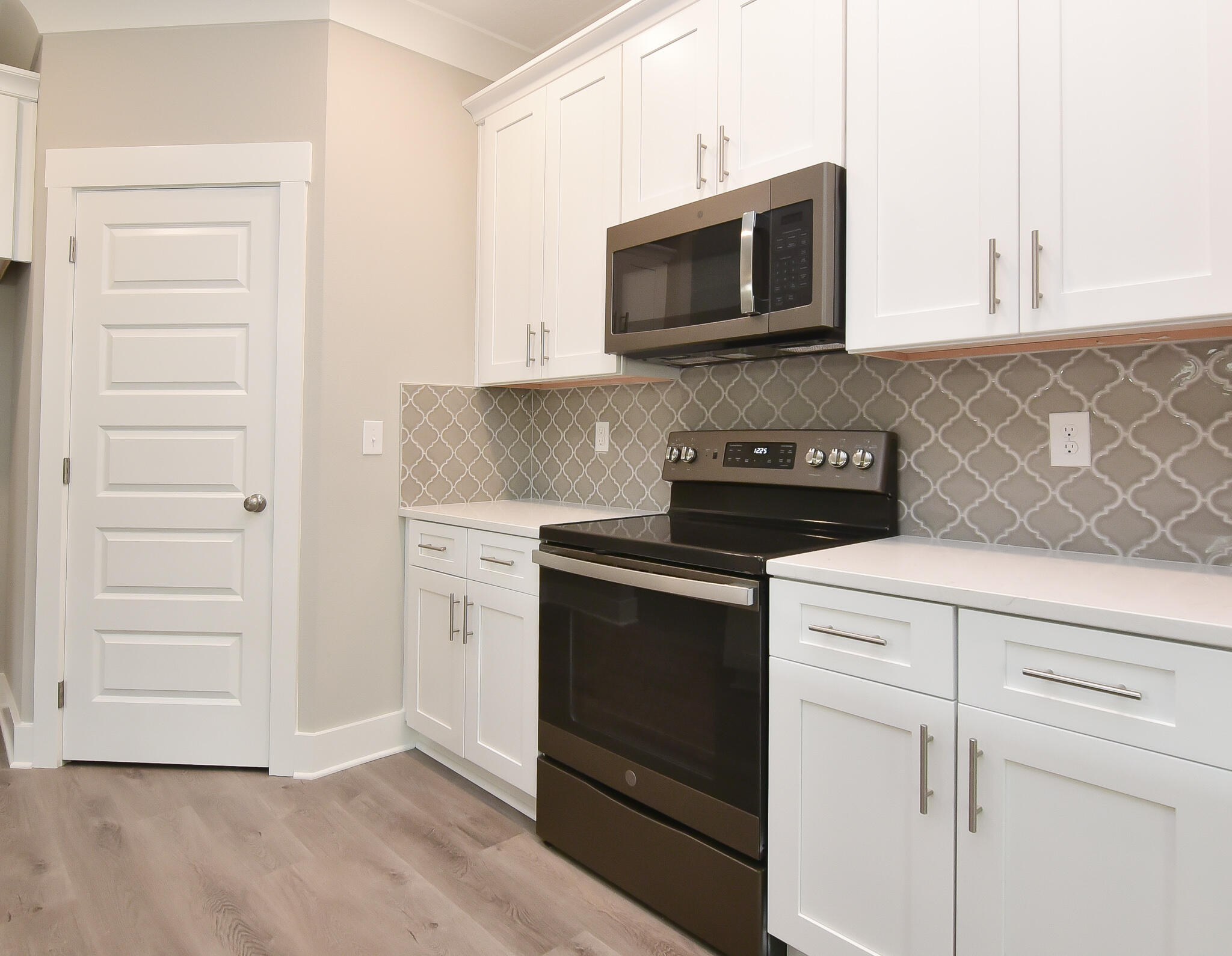 667 Red Fern Road Crestview, FL 32536 - Photo 11 of 32 a kitchen with white cabinets and stainless steel appliances