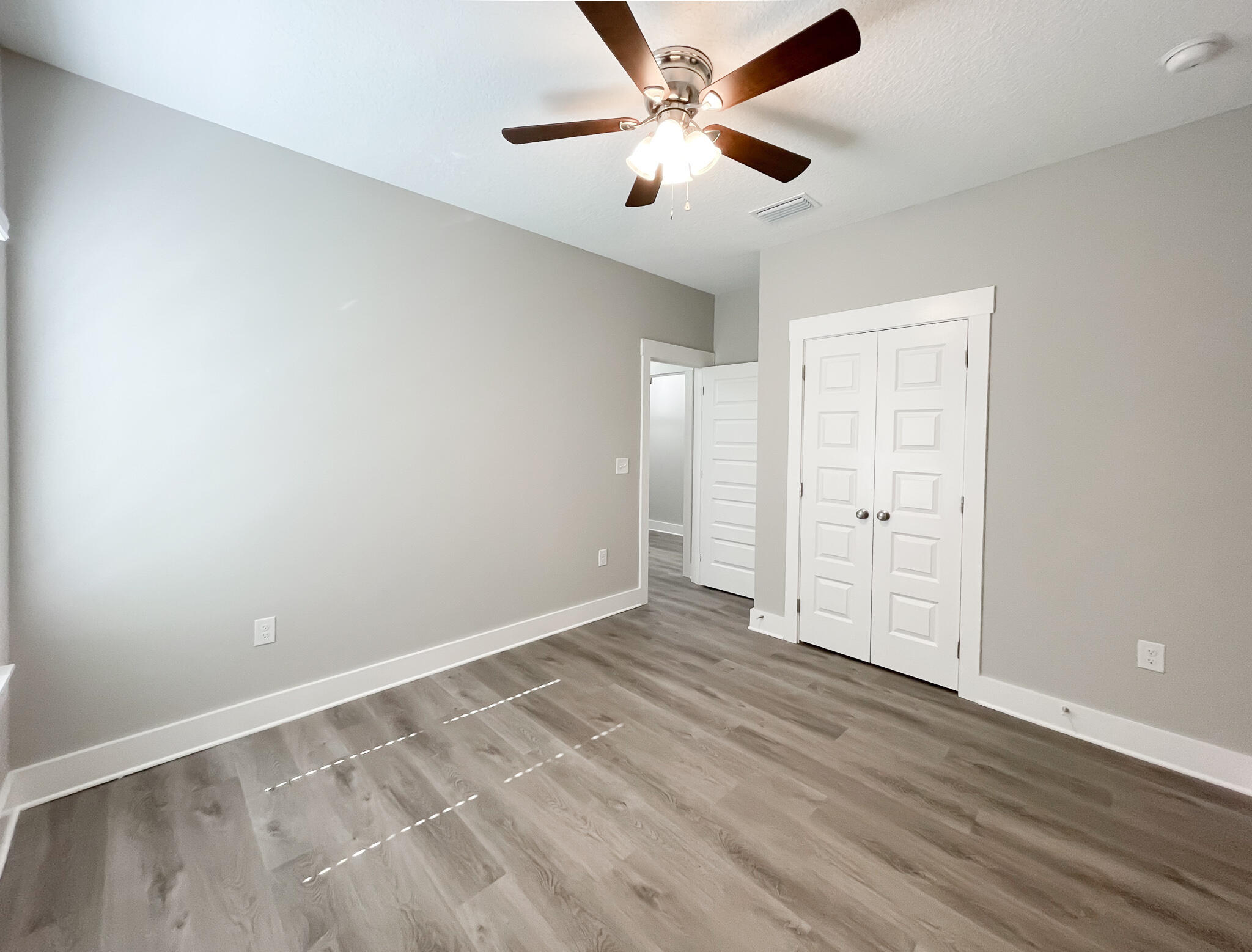 667 Red Fern Road Crestview, FL 32536 - Photo 28 of 32 an empty room with wooden floor and ceiling fan
