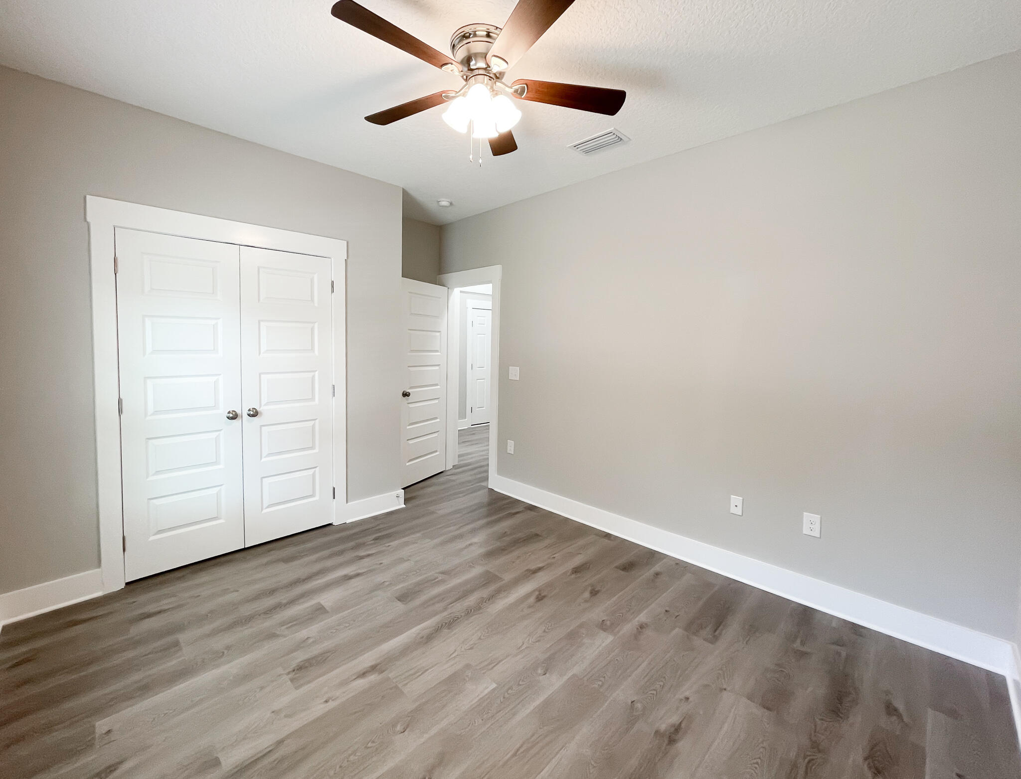 667 Red Fern Road Crestview, FL 32536 - Photo 29 of 32 an empty room with wooden floor ceiling fan and windows