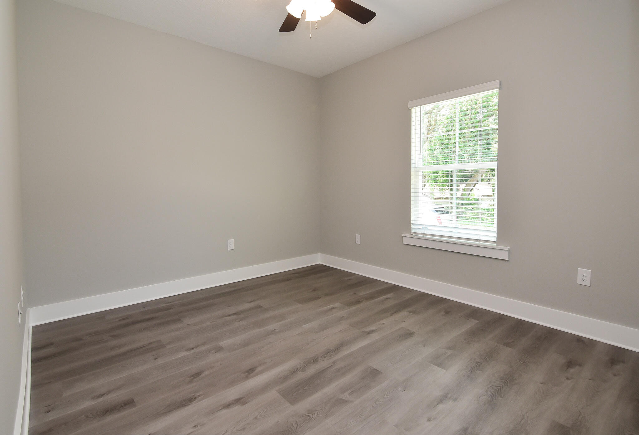 667 Red Fern Road Crestview, FL 32536 - Photo 4 of 32 an empty room with wooden floor and windows