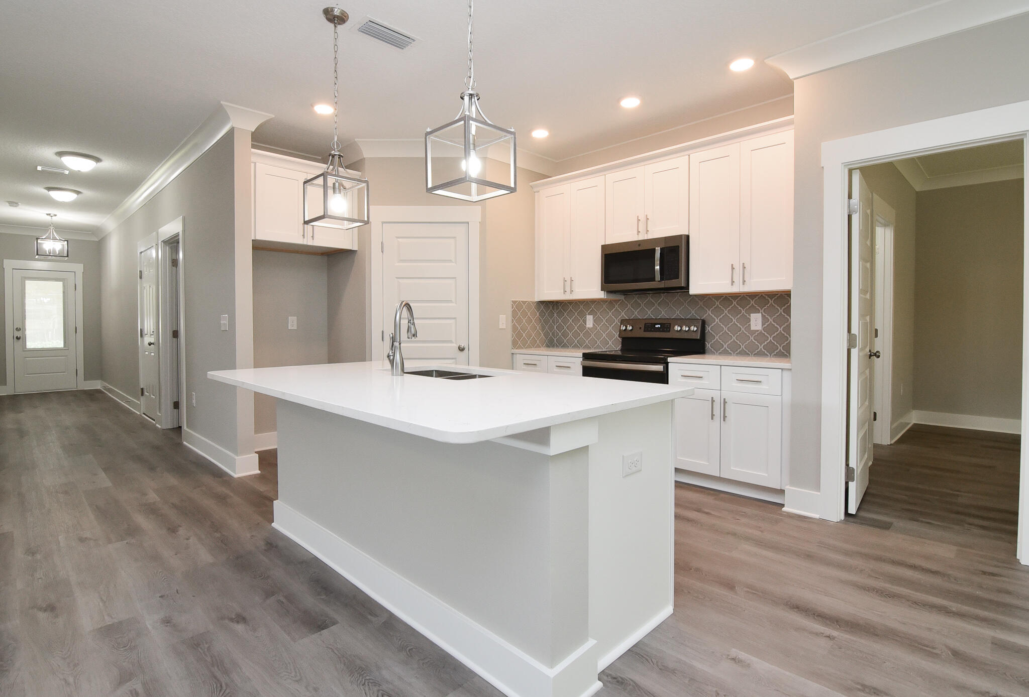 667 Red Fern Road Crestview, FL 32536 - Photo 9 of 32 a kitchen with kitchen island a sink and a stove top oven