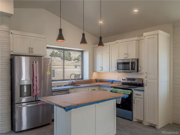 a kitchen with stainless steel appliances a sink a stove a refrigerator and cabinets