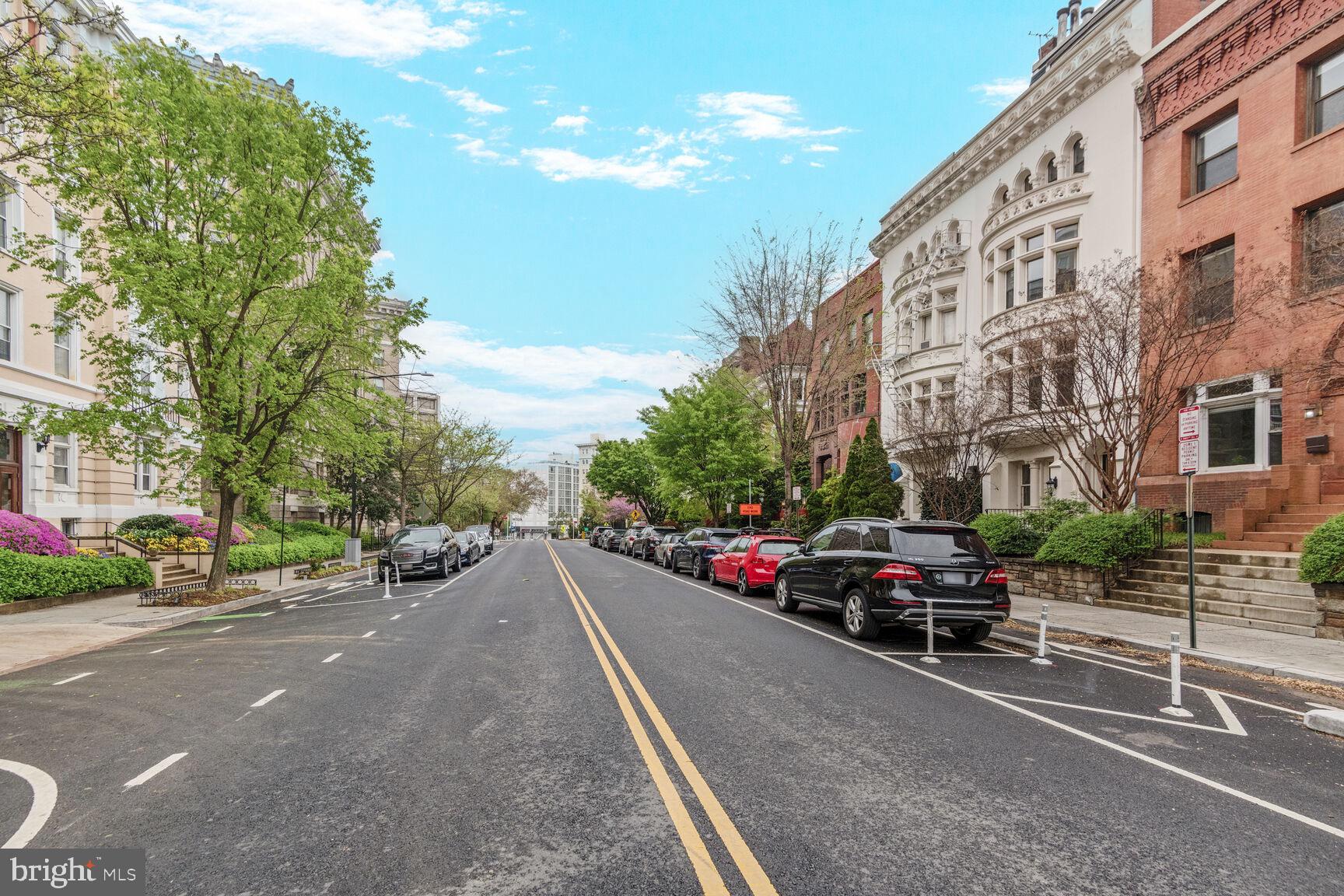 2009 Columbia Road Northwest, Unit 3 Washington, DC 20009 - Photo 13 of 16 a road view with tall buildings and cars parked on the side of road