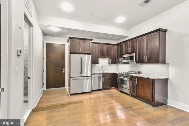 a large kitchen with cabinets and stainless steel appliances