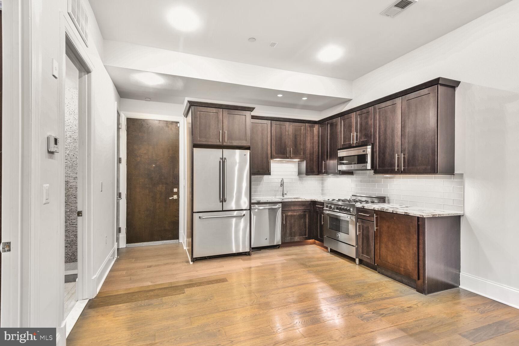 2009 Columbia Road Northwest, Unit 3 Washington, DC 20009 - Photo 5 of 16 a large kitchen with cabinets and stainless steel appliances