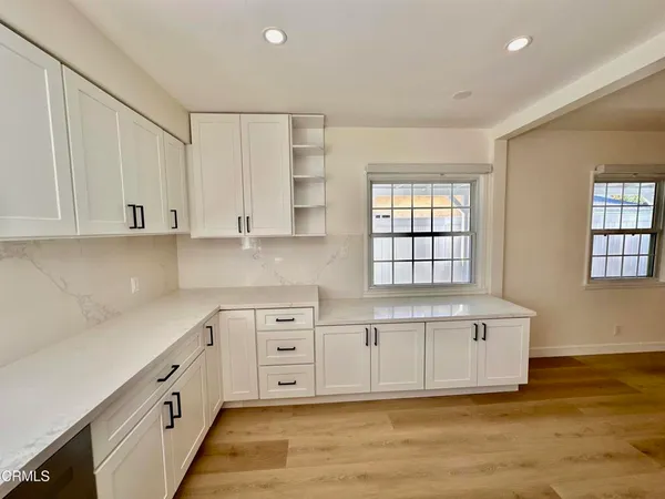 a kitchen with granite countertop white cabinets and white appliances