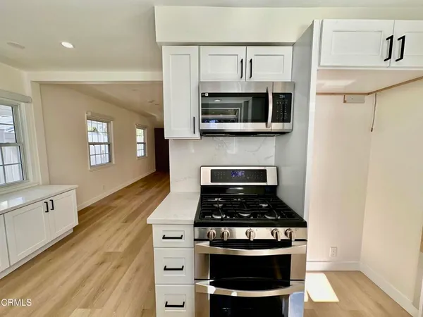 a kitchen with stainless steel appliances a stove a microwave and cabinets