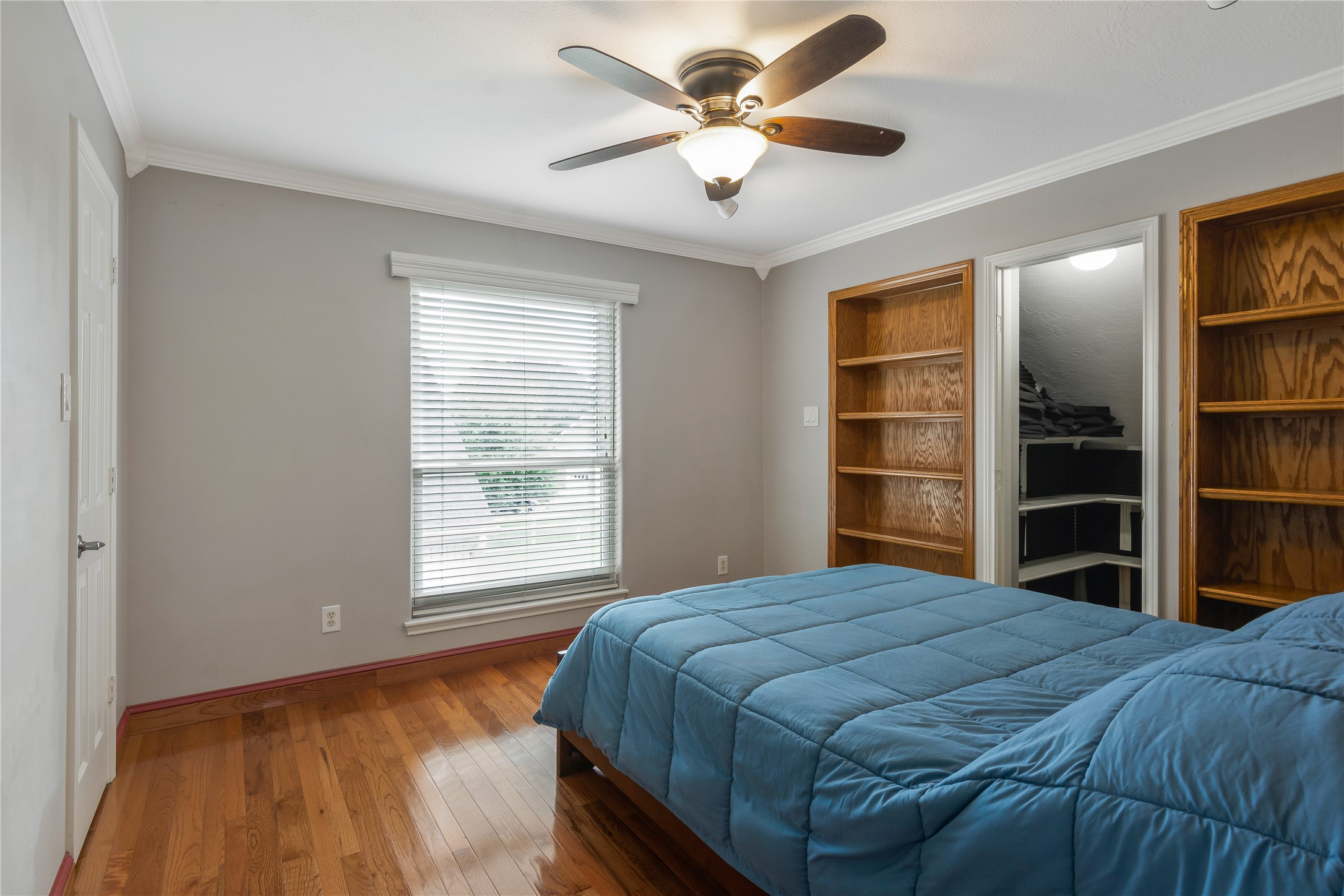 13914 Skinner Road Cypress, TX 77429 - Photo 20 of 50 Bedroom with hardwood floors, a tray ceiling, ceiling fan, large window, and built in shelving.
