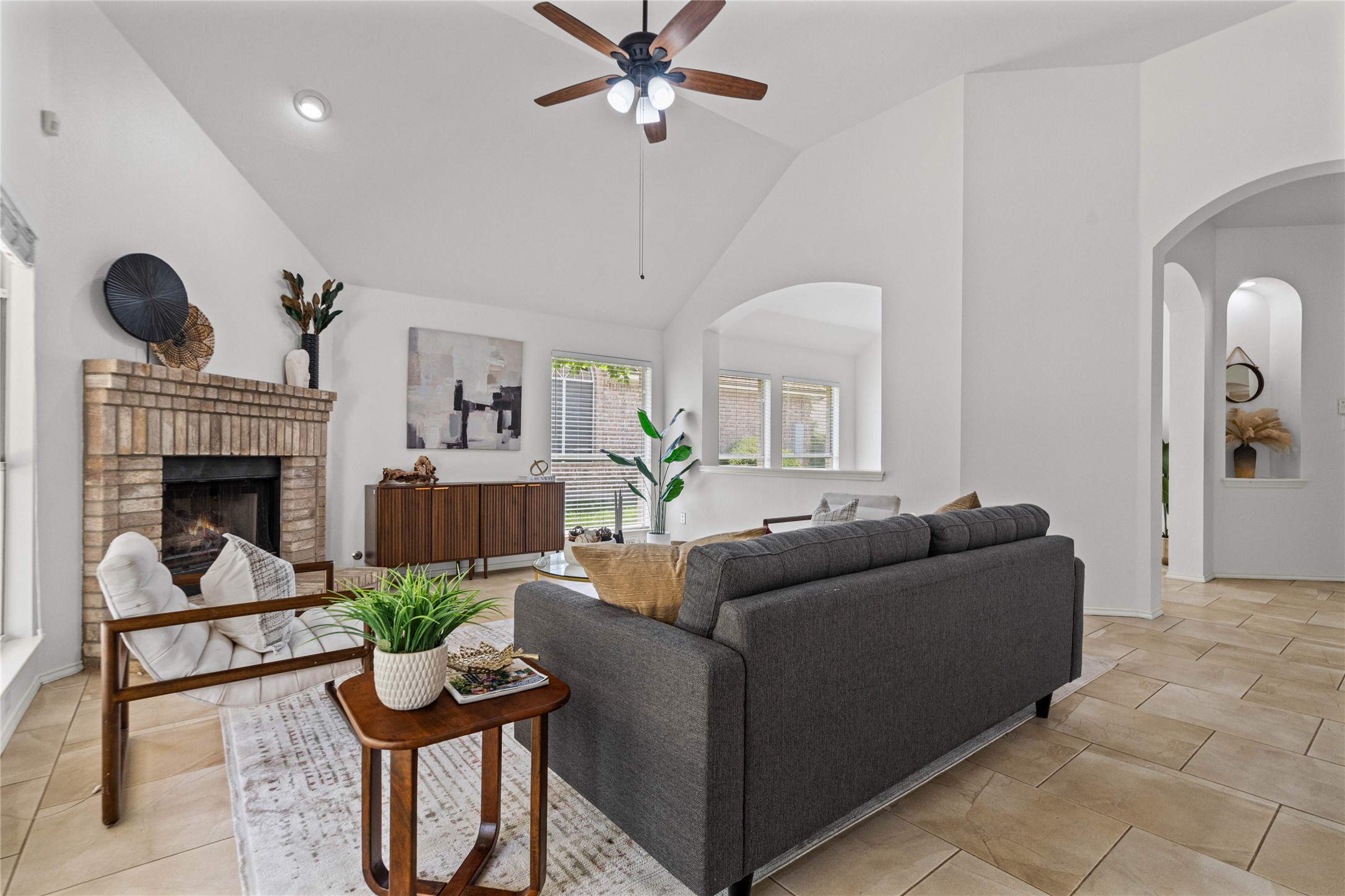 2920 Warwick Way Austin, TX 78748 - Photo 9 of 36 A vaulted ceiling living area features a brick fireplace and warm-toned tile flooring