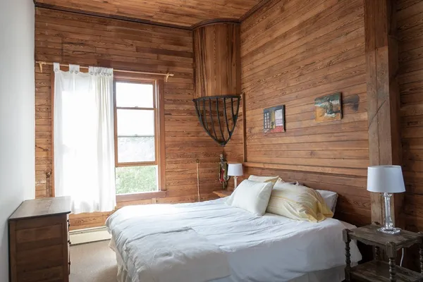 a bedroom with a bed and a lamp next to a window