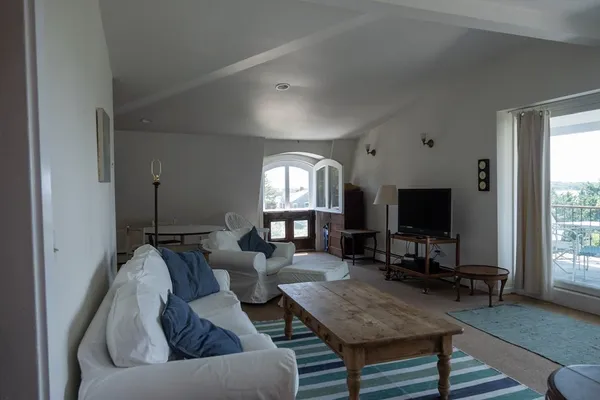 a living room with furniture a large window and a flat screen tv