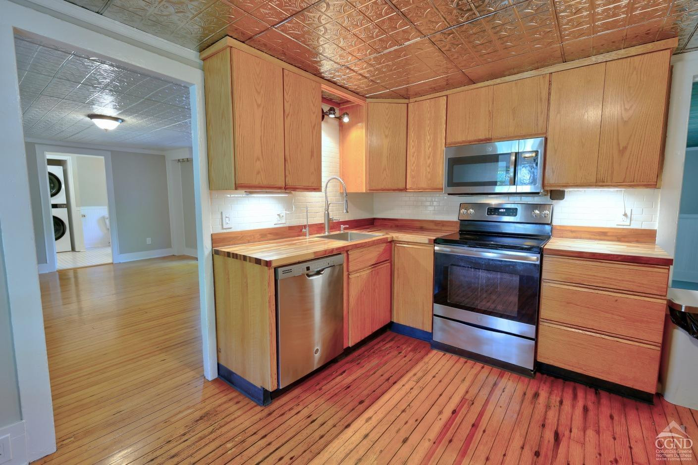 21 Irondale Road Millerton, NY 12546 - Photo 24 of 73 a kitchen with stainless steel appliances kitchen island wooden floors wooden cabinets and entryway