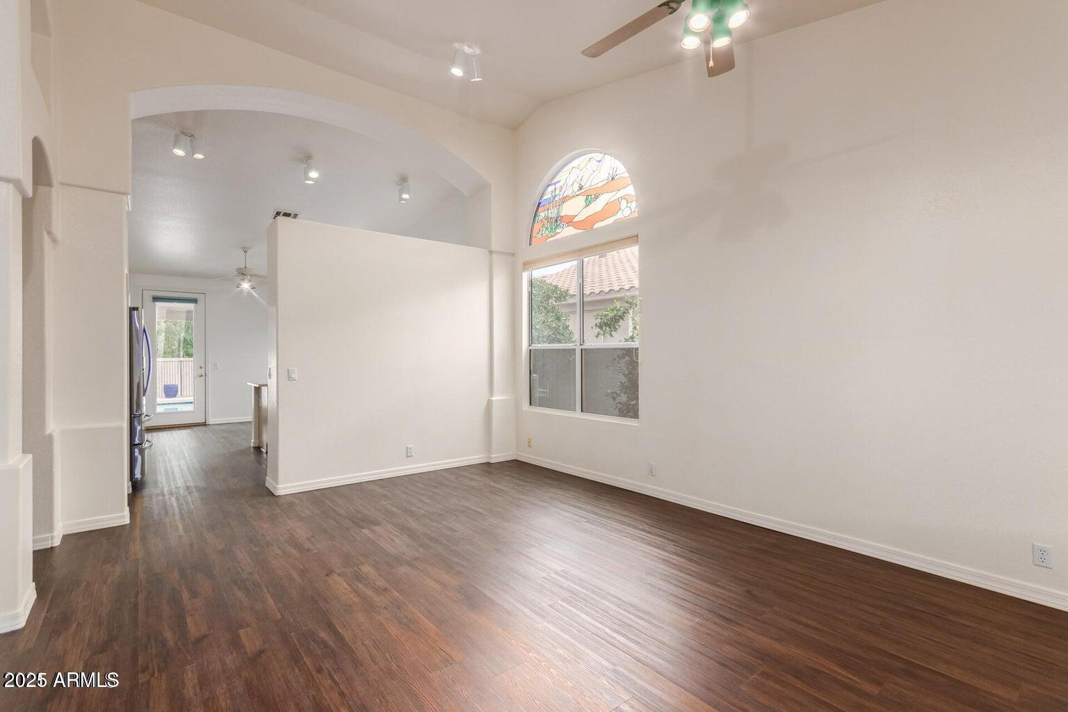 6230 West Irma Lane Glendale, AZ 85308 - Photo 12 of 21 an empty room with wooden floor and windows