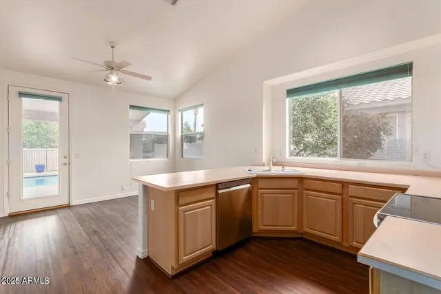 a kitchen with a sink window and wooden floor