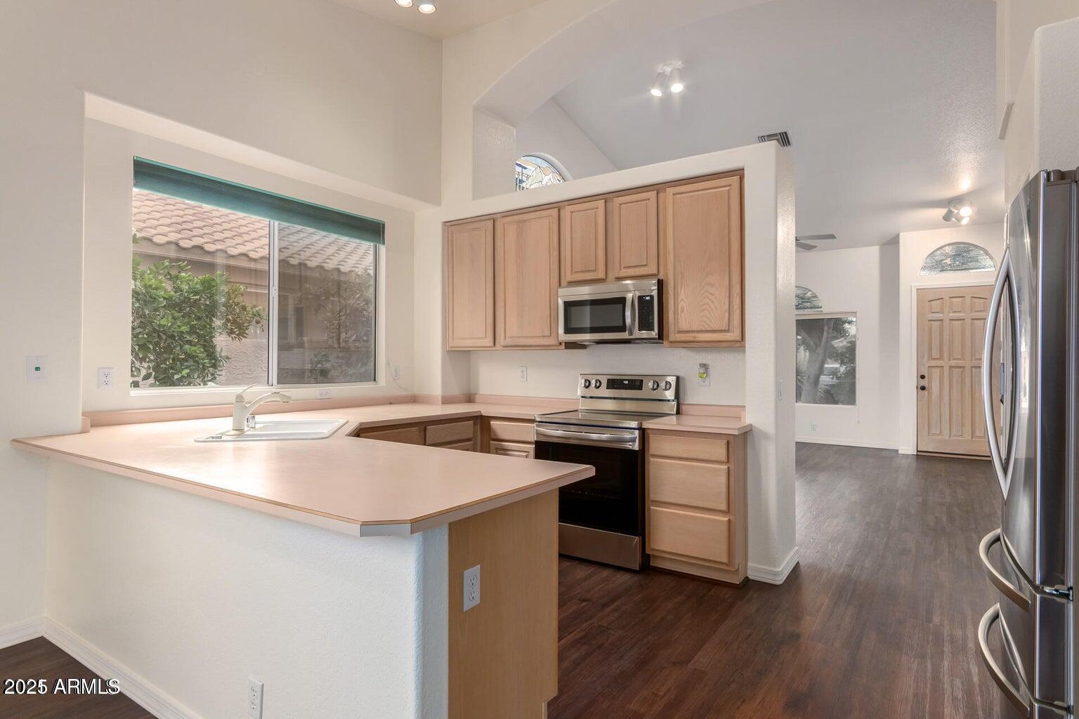 6230 West Irma Lane Glendale, AZ 85308 - Photo 15 of 21 a kitchen with stainless steel appliances granite countertop a sink stove and refrigerator