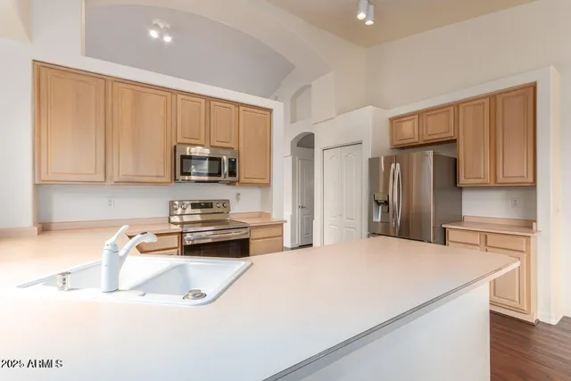 a kitchen with stainless steel appliances granite countertop a refrigerator a stove top oven a sink and dishwasher