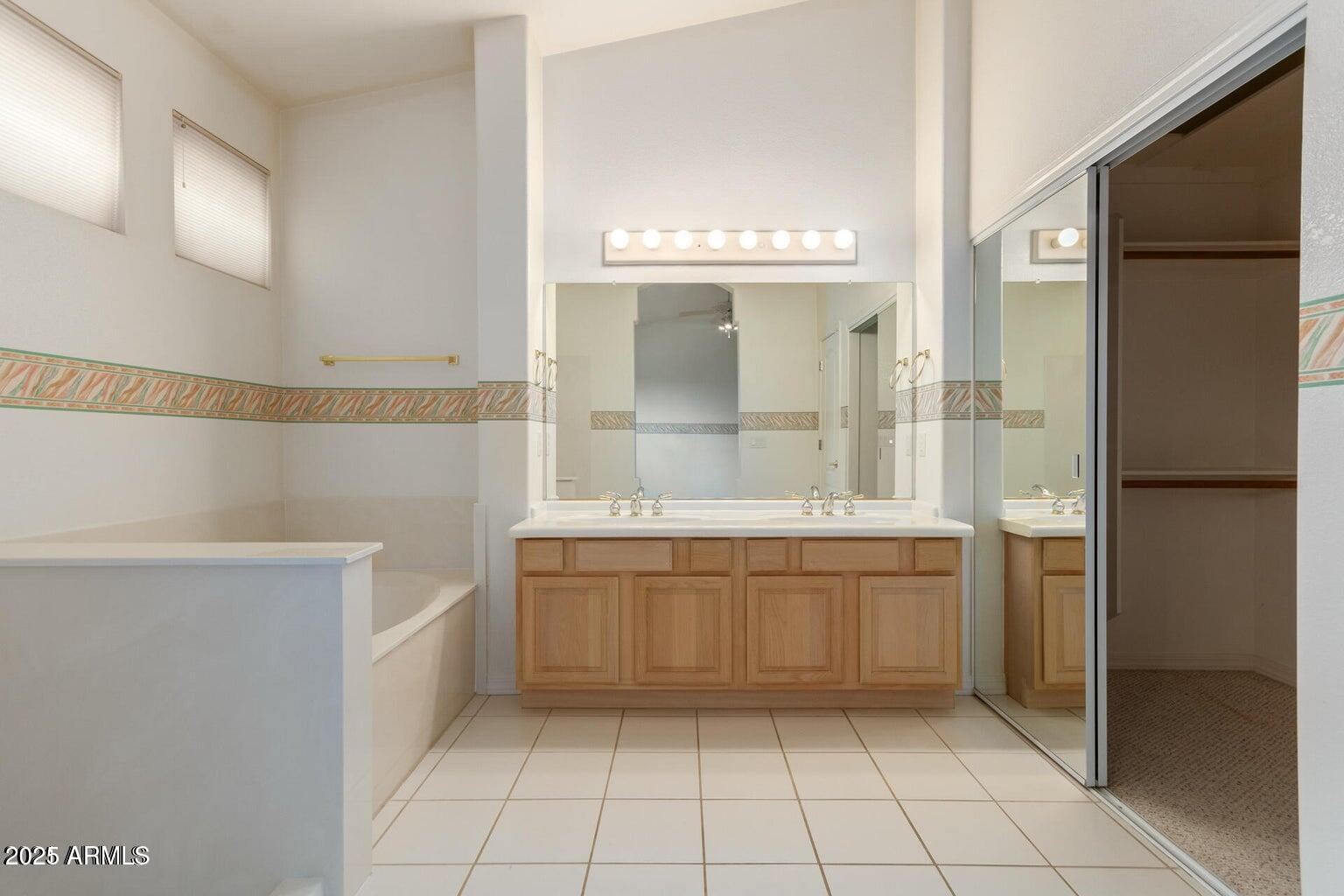 6230 West Irma Lane Glendale, AZ 85308 - Photo 21 of 21 a bathroom with a granite countertop sink a mirror and a bathtub