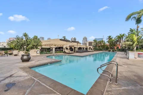 a living room with furniture a large window and stainless steel appliances